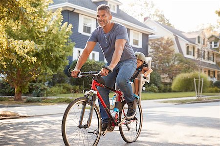 Father Cycling Along Street With Daughter In Child Seat Stock Photo - Budget Royalty-Free & Subscription, Code: 400-09122249