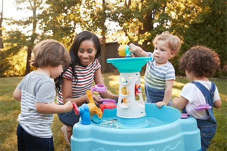 Mother And Young Children Playing With Water Table In Garden Stock Photo - Budget Royalty-Free & Subscription, Code: 400-09122270