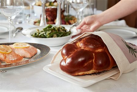 Hand placing dish on table set for Jewish Shabbat, close up Foto de stock - Super Valor sin royalties y Suscripción, Código: 400-09122343