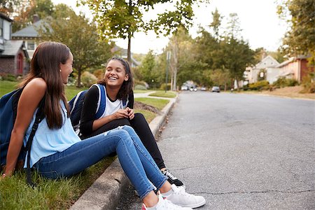 Two teen girlfriends sit talking at the roadside Stock Photo - Budget Royalty-Free & Subscription, Code: 400-09122441