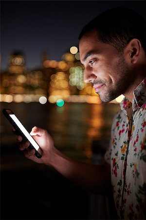 Man Using Mobile Phone At Night With City Skyline In Background Stock Photo - Budget Royalty-Free & Subscription, Code: 400-09122717