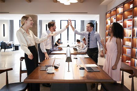 Four colleagues celebrating success in an open plan office Stock Photo - Budget Royalty-Free & Subscription, Code: 400-09122837