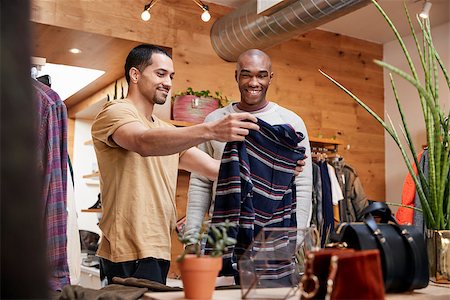 Two young men holding up clothes to look at in clothes shop Stock Photo - Budget Royalty-Free & Subscription, Code: 400-09122941