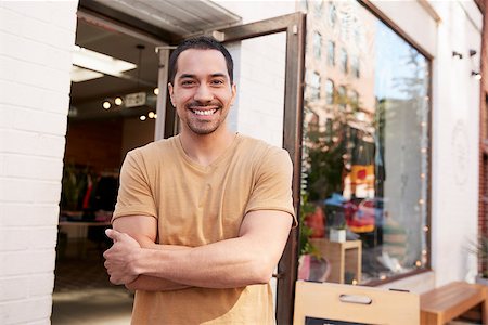 simsearch:400-08838017,k - Young Hispanic shop owner smiling to camera outside his shop Photographie de stock - Aubaine LD & Abonnement, Code: 400-09122956