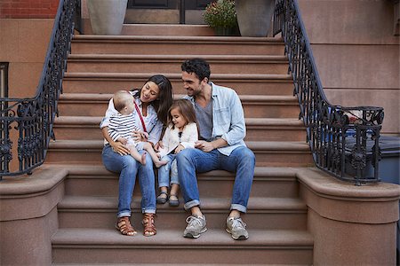 sandsteinhaus - Young family with kids sitting on front stoops Stockbilder - Microstock & Abonnement, Bildnummer: 400-09123175