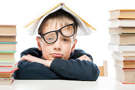 tired schoolboy and piles of books on white background, close-up portrait Stock Photo - Budget Royalty-Free & Subscription, Code: 400-09136290