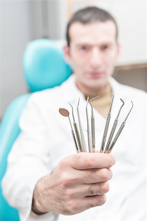 probe - Dentist holding his tools in his outstretched hand, close-up. Blurred background Photographie de stock - Aubaine LD & Abonnement, Code: 400-09136707