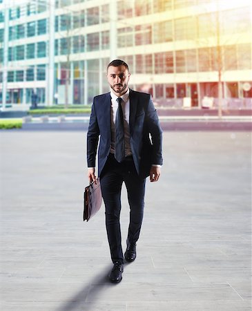 enterprise strength - Businessman walking on the street with skyscraper background. Stock Photo - Budget Royalty-Free & Subscription, Code: 400-09131864