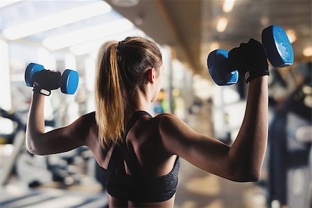 simsearch:400-08505882,k - Athletic muscular woman trains biceps with dumbbells at the gym Stock Photo - Budget Royalty-Free & Subscription, Code: 400-09131861