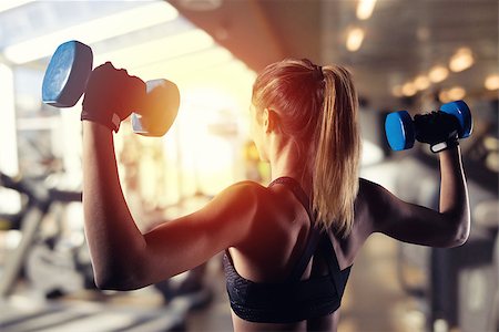 simsearch:400-08505882,k - Athletic muscular woman trains biceps with dumbbells at the gym Stock Photo - Budget Royalty-Free & Subscription, Code: 400-09131902