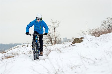 simsearch:400-09132505,k - Cyclist in Blue Riding the Mountain Bike on the Rocky Winter Hill Covered with Snow. Extreme Sport and Enduro Biking Concept. Foto de stock - Super Valor sin royalties y Suscripción, Código: 400-09132166