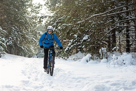 simsearch:400-09084281,k - Cyclist in Blue Riding the Mountain Bike in the Beautiful Winter Forest Covered with Snow. Extreme Sport and Enduro Biking Concept. Fotografie stock - Microstock e Abbonamento, Codice: 400-09132504