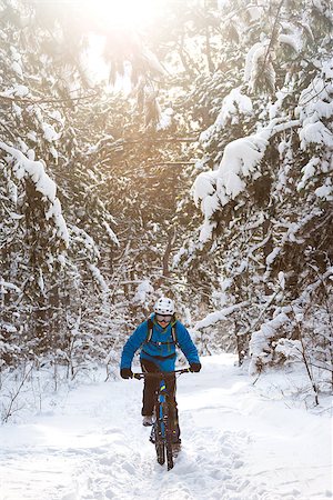 simsearch:400-09084281,k - Cyclist in Blue Riding the Mountain Bike in the Beautiful Winter Forest Lit by the Sun and Covered with Snow. Extreme Sport and Enduro Biking Concept. Fotografie stock - Microstock e Abbonamento, Codice: 400-09132506