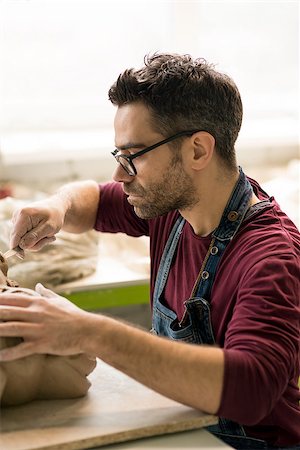 pottery sculpt - Ceramist Dressed in an Apron Sculpting Statue from Raw Clay in the Bright Ceramic Workshop. Stock Photo - Budget Royalty-Free & Subscription, Code: 400-09132517