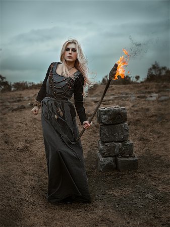 simsearch:400-07776243,k - Witch in a long black dress walking through the village in the dark Fotografie stock - Microstock e Abbonamento, Codice: 400-09132992