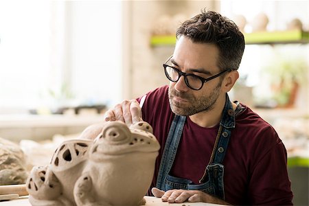 pottery sculpt - Ceramist Dressed in an Apron Sculpting Statue from Raw Clay in the Bright Ceramic Workshop. Stock Photo - Budget Royalty-Free & Subscription, Code: 400-09133214