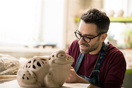 pottery sculpt - Ceramist Dressed in an Apron Sculpting Statue from Raw Clay in the Bright Ceramic Workshop. Stock Photo - Budget Royalty-Free & Subscription, Code: 400-09133215