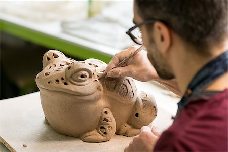 pottery sculpt - Ceramist Dressed in an Apron Sculpting Statue from Raw Clay in the Bright Ceramic Workshop. Stock Photo - Budget Royalty-Free & Subscription, Code: 400-09133216