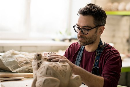pottery sculpt - Ceramist Dressed in an Apron Sculpting Statue from Raw Clay in the Bright Ceramic Workshop. Stock Photo - Budget Royalty-Free & Subscription, Code: 400-09133217