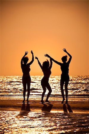 simsearch:400-04087417,k - Three beautiful young women in bikinis dancing on a beach at sunset all in silhouette Stock Photo - Budget Royalty-Free & Subscription, Code: 400-09140479