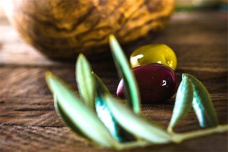 simsearch:400-05666507,k - olives on olive branch. Wooden table with olives in bowl Stock Photo - Budget Royalty-Free & Subscription, Code: 400-09140628