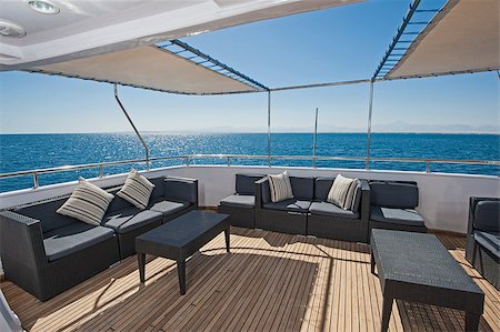 simsearch:400-05215932,k - Rear teak deck of a large luxury motor yacht with chairs sofa table and tropical sea view background Foto de stock - Super Valor sin royalties y Suscripción, Código: 400-09140717