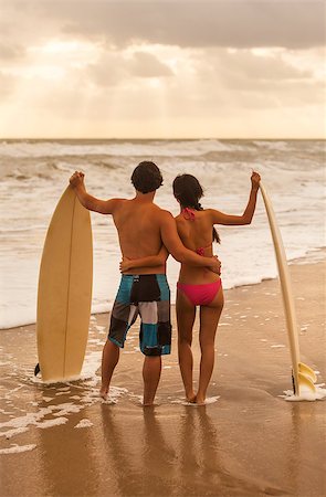 Rear view of young Asian man & woman, boy & girl, couple on a beach surfing with surfboards Stock Photo - Budget Royalty-Free & Subscription, Code: 400-09141090