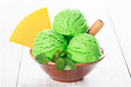 simsearch:400-08223858,k - Scoop of pistachio ice cream in bowl on wooden background. Photographie de stock - Aubaine LD & Abonnement, Code: 400-09151307