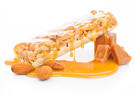simsearch:400-09186057,k - Caramel protein cereal energy bar with liquid toffee and almonds on white background Foto de stock - Super Valor sin royalties y Suscripción, Código: 400-09186014