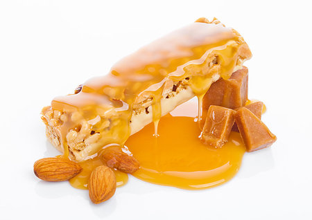 simsearch:400-09238081,k - Caramel protein cereal energy bar with liquid toffee and almonds on white background Photographie de stock - Aubaine LD & Abonnement, Code: 400-09186013