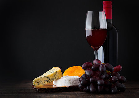 simsearch:400-06461717,k - Bottle and glass of red wine with cheese selection with grapes on black background Stock Photo - Budget Royalty-Free & Subscription, Code: 400-09186036