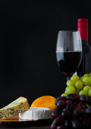 simsearch:400-08074810,k - Bottle and glass of red wine with cheese selection with grapes on black background Photographie de stock - Aubaine LD & Abonnement, Code: 400-09186037