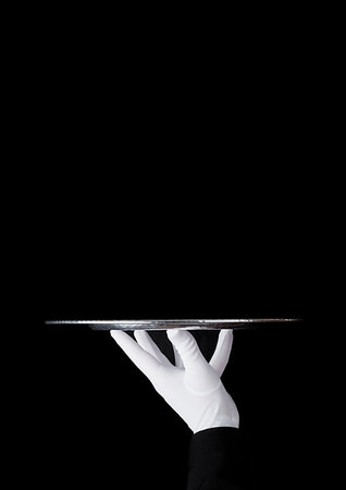 simsearch:400-05230474,k - Servant wearing white glove holds stainless steel tray on black background Stock Photo - Budget Royalty-Free & Subscription, Code: 400-09186188