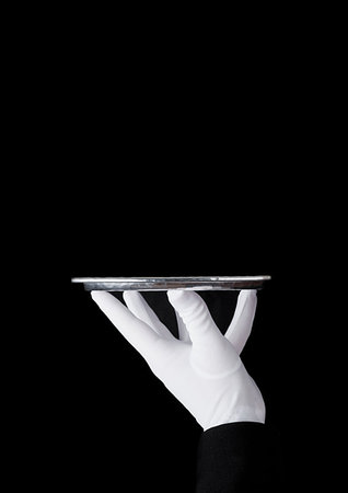 simsearch:400-05230474,k - Servant wearing white glove holds stainless steel tray on black background Stock Photo - Budget Royalty-Free & Subscription, Code: 400-09186189