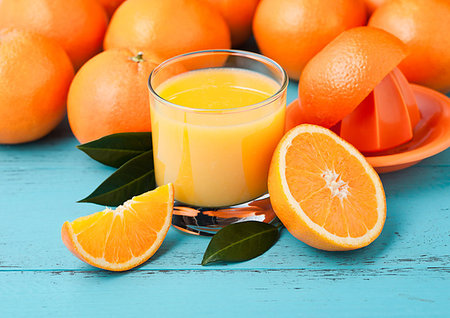 simsearch:649-08422911,k - Glass of organic fresh orange smoothie juice with raw oranges on blue wooden  background. Stockbilder - Microstock & Abonnement, Bildnummer: 400-09186306
