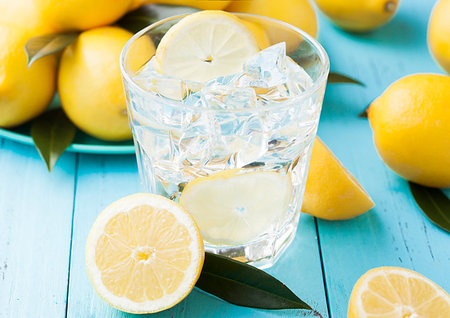 denismart (artist) - Glass of organic fresh lemon still summer water with raw lemons on blue wooden background.Top view Foto de stock - Royalty-Free Super Valor e Assinatura, Número: 400-09186343