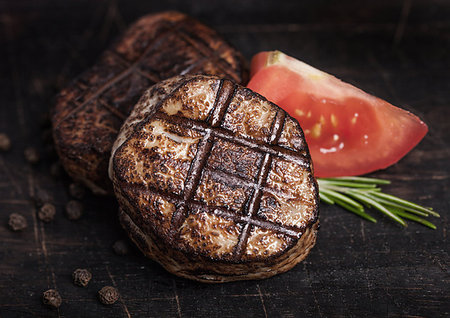 simsearch:400-06464712,k - Grilled juicy beef pork steak slice on wooden background with pepper and rosemarine herb Photographie de stock - Aubaine LD & Abonnement, Code: 400-09186383