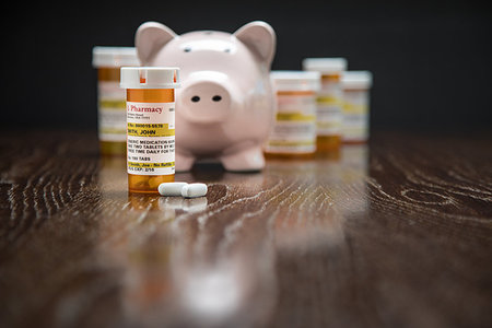 simsearch:400-08862116,k - Variety of Non-Proprietary Prescription Medicine Bottles, Pills and Piggy Bank on Reflective Wooden Surface. Stock Photo - Budget Royalty-Free & Subscription, Code: 400-09193462