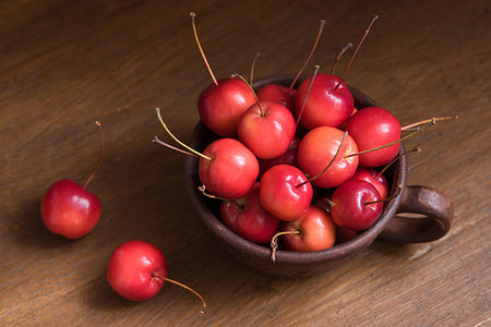 Small crab apples in the cup. Wild apples strewn around the cup Fotografie stock - Microstock e Abbonamento, Codice: 400-09193475