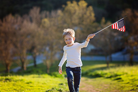 simsearch:400-07558325,k - positive little boy with american flag running and celebrating 4th of july, independence day, or memorial day Photographie de stock - Aubaine LD & Abonnement, Code: 400-09224729