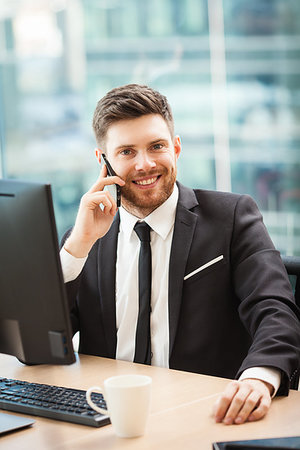 simsearch:400-04180586,k - Young businessman at the office sitting at his desk and talking on a phone Stockbilder - Microstock & Abonnement, Bildnummer: 400-09225826