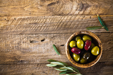 simsearch:400-05666507,k - olives on olive branch. Wooden table with olives in bowl Stock Photo - Budget Royalty-Free & Subscription, Code: 400-09225965