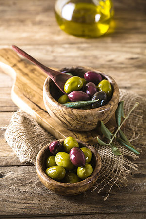 simsearch:400-05666507,k - olives on olive branch. Wooden table with olives in bowl Stock Photo - Budget Royalty-Free & Subscription, Code: 400-09226018