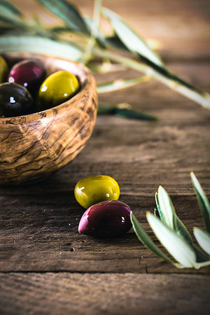 simsearch:400-05666507,k - olives on olive branch. Wooden table with olives in bowl Stock Photo - Budget Royalty-Free & Subscription, Code: 400-09220875