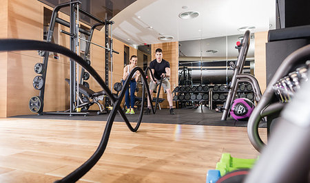 simsearch:400-09221277,k - Low-angle view of a young determined man waving battle ropes with alternative motion during an intense session of functional training in the gym Stock Photo - Budget Royalty-Free & Subscription, Code: 400-09221277