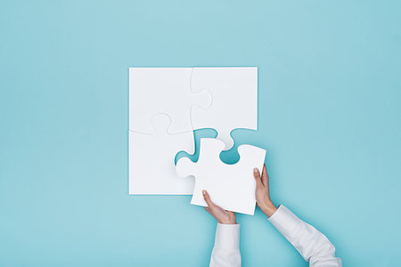 Woman assembling a jigsaw puzzle she is adding the last missing piece, solutions and challenges concept Stock Photo - Budget Royalty-Free & Subscription, Code: 400-09221542