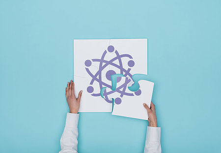 Woman completing a puzzle with atom icon, she is putting the missing piece, physics and science concept Stock Photo - Budget Royalty-Free & Subscription, Code: 400-09221746