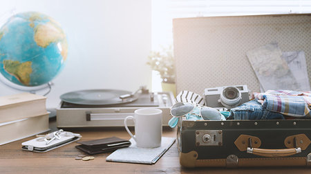 simsearch:400-09222181,k - Traveler packing his luggage before leaving for a vacation: open vintage suitcase with clothes, camera and vintage record player, travel and retro revival concept Fotografie stock - Microstock e Abbonamento, Codice: 400-09221741