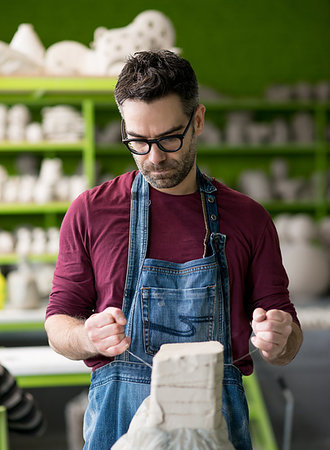 pottery sculpt - Ceramist Dressed in an Apron Working with Raw Clay in the Bright Ceramic Workshop. Stock Photo - Budget Royalty-Free & Subscription, Code: 400-09221939