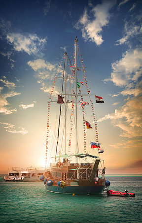 Wooden sailboat in the sea at sunset Stockbilder - Microstock & Abonnement, Bildnummer: 400-09222069